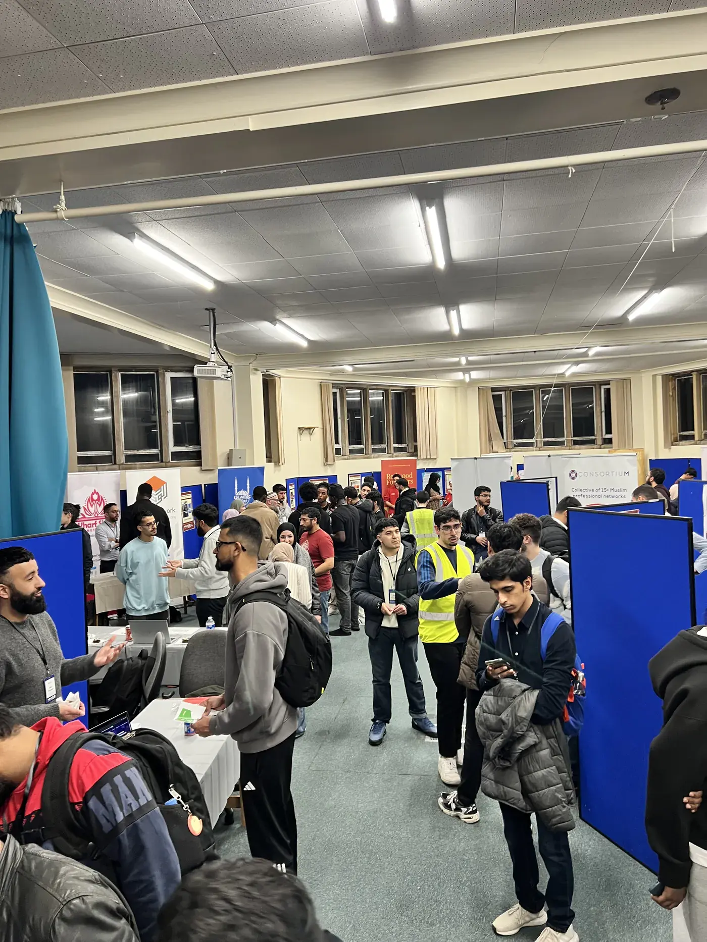 A busy hall of employer stands at an IHSAAN careers fair