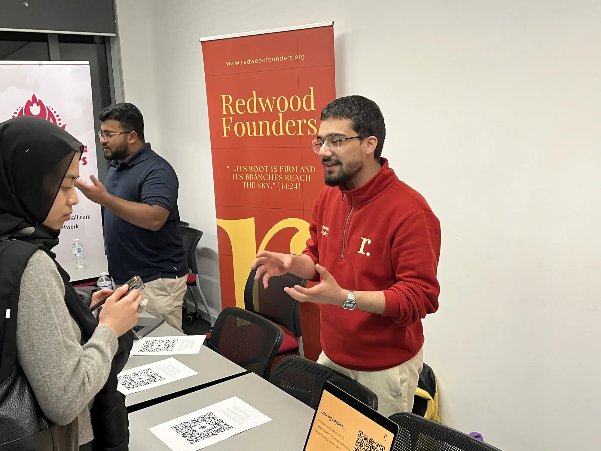 A Redwood Founders representative talking with a student at their stand