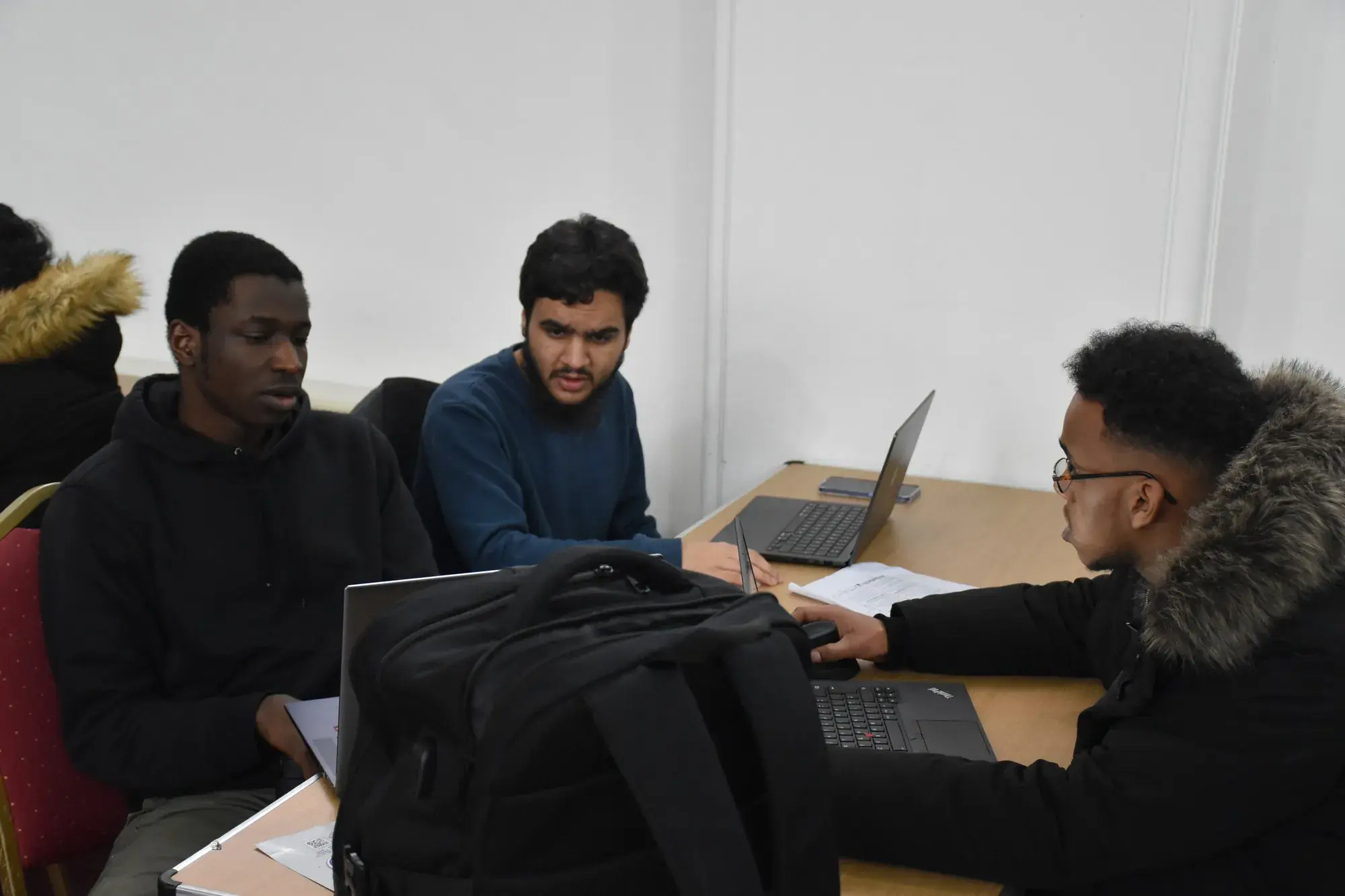 Students discussing their idea around a laptop